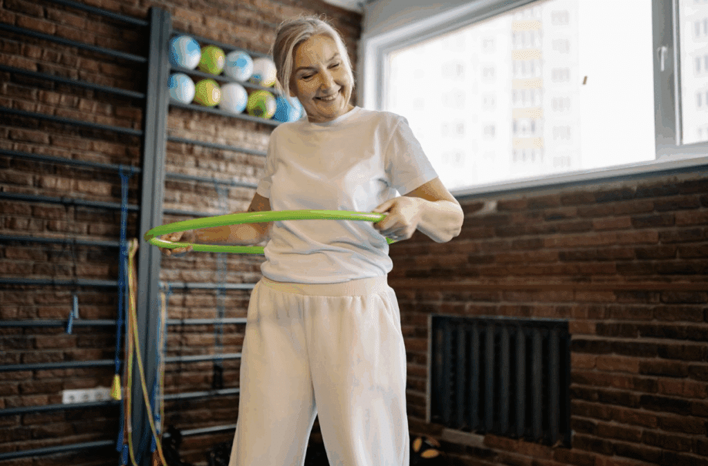 A senior woman doing a hula hoop exercise