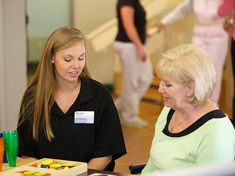A female caregiver helps a patient with speech therapy
