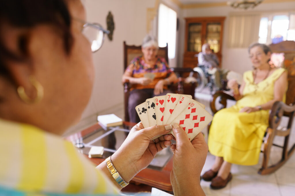 Wyoming senior helathcare game night, three women have playing cards in their hands.